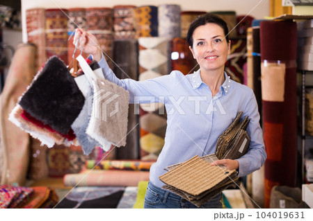 Glad woman shopping carpet and showing samples Glad woman shopping carpet and showing samples 104019631