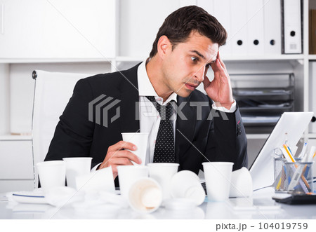 Tired man working in hot office 104019759