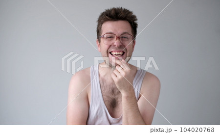 A sarcastic man in big glasses mockingly laughs and points his finger at the camera 104020768