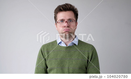 The angry European young man wearily looks. He is without strength and energy The angry European young man wearily looks. He is without strength and energy 104020780