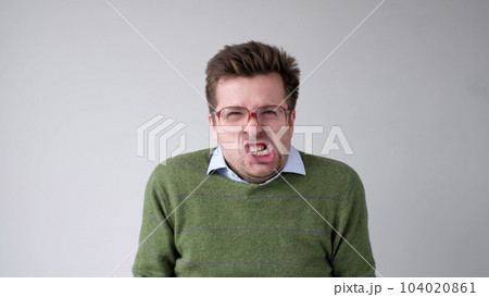 European young man is dissatisfied with the result, he gets angry and contorts a grimace of aggression 104020861