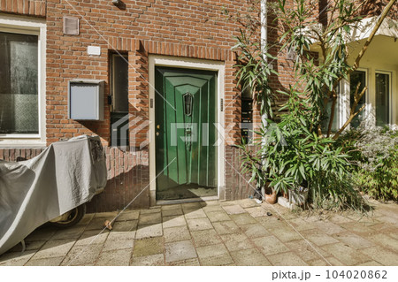 an outside view of a house with a green door and plants in the fore - image was taken from google's street an outside view of a house with a green door and plants in the fore - image was taken from google's street 104020862