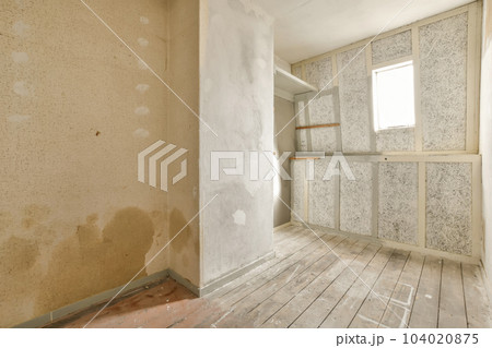 an unfinished room with wood flooring and wallpapers on the walls, in need of renovation or reurrectionment 104020875