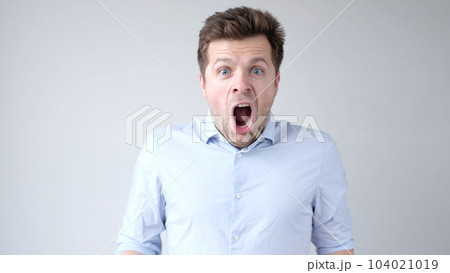 European young man is greatly surprised and opens his mouth in astonishment European young man is greatly surprised and opens his mouth in astonishment 104021019