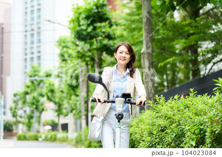 電動キックボードを運転をする女性 電動キックボードを運転をする女性 104023084