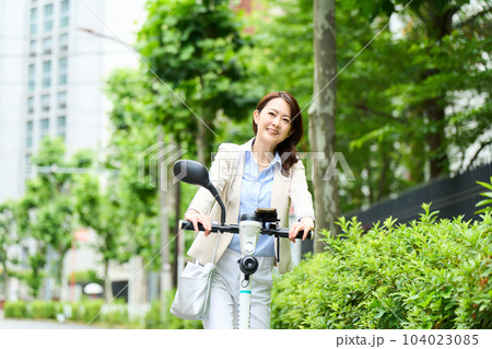 電動キックボードを運転をする女性 電動キックボードを運転をする女性 104023085