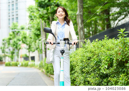 電動キックボードを運転をする女性 104023086