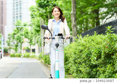 電動キックボードを運転をする女性 電動キックボードを運転をする女性 104023087