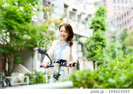 電動キックボードを運転をする女性 電動キックボードを運転をする女性 104023093