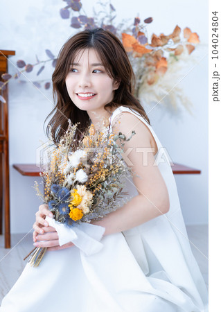 ドライフラワーの花束を持つ白ワンピースの女性 104024804