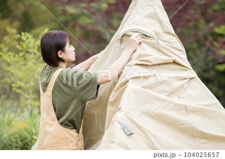 キャンプ場でテント設営をする若い女性　ソロキャン　ソロキャンパー 104025657