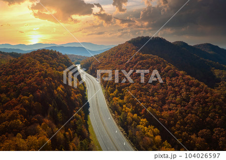 View from above of empty deserted I-40 freeway route in North Carolina leading to Asheville thru Appalachian mountains with yellow fall woods. Interstate transportation concept 104026597