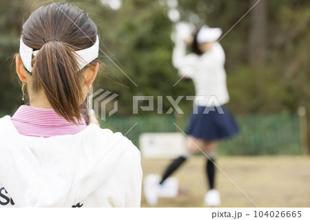 ゴルフプレイ中スマホで友達のスイングを撮影をするゴルフ女子 ゴルフプレイ中スマホで友達のスイングを撮影をするゴルフ女子 104026665