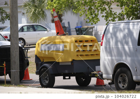 Utility van with yellow compressor trailer with jackhammer machine on road construction site Utility van with yellow compressor trailer with jackhammer machine on road construction site 104026722
