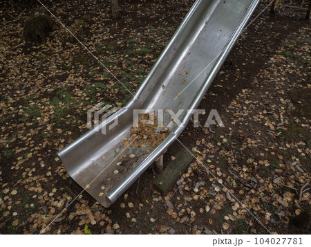 昼でもなお暗い初夏の山里　使われていない滑り台に溜まる落ち葉 104027781