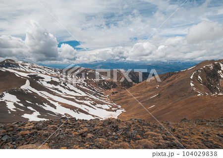 Fascinating view of the steep snowy slopes in the Pyrenees mountains on a cloudy spring sky. Spanish and French mountain nature concept. Copyspace 104029838