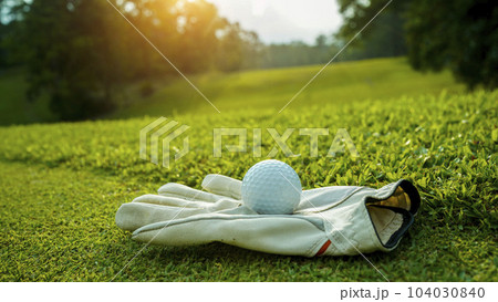 Golf glove and ball on green grass of golf course. close up view. 104030840