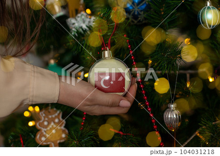 a girl holds a decoration on a Christmas tree with the flag of Turkey 104031218