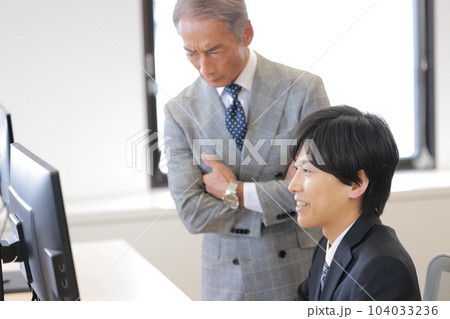 上司から依頼された仕事の進み具合を聞かれヘラヘラ笑っているビジネスマン_1 上司から依頼された仕事の進み具合を聞かれヘラヘラ笑っているビジネスマン_1 104033236