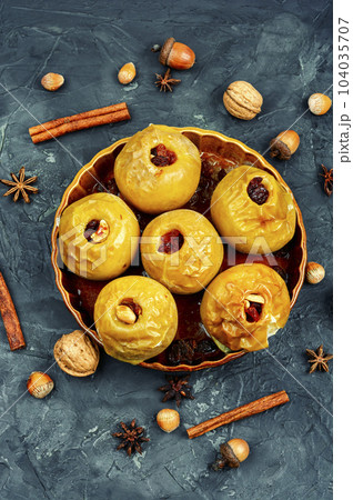 Baked autumn apples with nuts and raisins 104035707