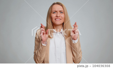 Business woman crossed fingers looking at camera asking for good luck news win victory in lottery 104036308