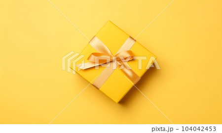 One yellow gift box in craft wrapping paper and satin ribbon with bow on yellow clean flat surface background, neural network generated image 104042453