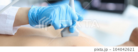 Doctor makes echocardiography of male patient using ultrasound probe pressing on patient chest Doctor makes echocardiography of male patient using ultrasound probe pressing on patient chest 104042621