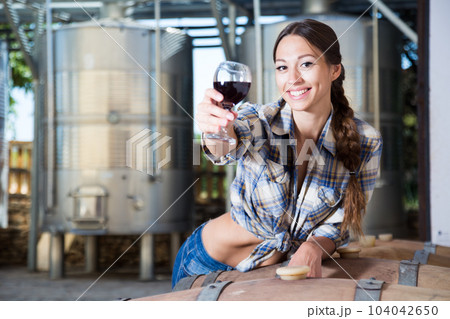 woman with glass of wine posing on the winery of spain 104042650