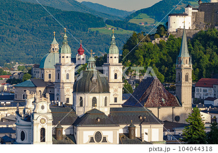 Salzburg, city in Austria, view at the old town and historic centre, with Collegiate Church, Franciscan Church and Salzburg Cathedral. In the distance a part of the medieval Hohensalzburg Fortress. 104044318