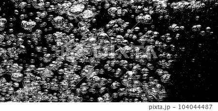 Soda water bubbles splashing underwater against black background. Cola liquid texture that fizzing and floating up to surface like a explosion in under water for refreshing carbonate drink concept. Soda water bubbles splashing underwater against black background. Cola liquid texture that fizzing and floating up to surface like a explosion in under water for refreshing carbonate drink concept. 104044487
