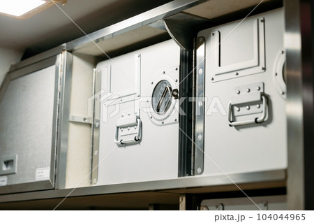 In flight safety cabinet on board food storage box in cabin crew service working area. In flight safety cabinet on board food storage box in cabin crew service working area. 104044965