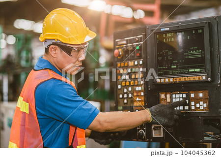 Industrial Asian worker operating lathe milling CNC machine at metal machining heavy industry. 104045362