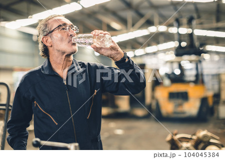 Thirsty senior male staff worker drinking water refreshing from tired hard work in hot workplace Thirsty senior male staff worker drinking water refreshing from tired hard work in hot workplace 104045384
