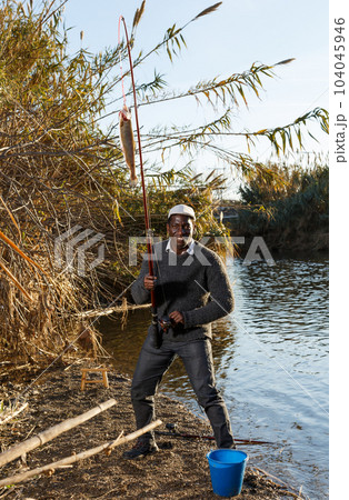 Man pulling fish on hook 104045946