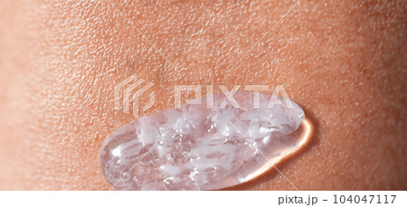 Collagen And Hyaluron Serum Gel On Skin. Splashing of Hyaluron gel. Liquid hyaluronic acid gel on skin. Cosmetic water gel texture on human skin background. Textured background. skin care product. 104047117