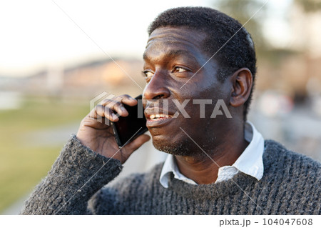 Cheerful Afro-American man talking on phone 104047608