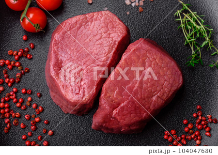 Raw beef eye steak round with salt, spices and herbs 104047680