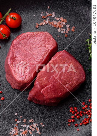 Raw beef eye steak round with salt, spices and herbs 104047681
