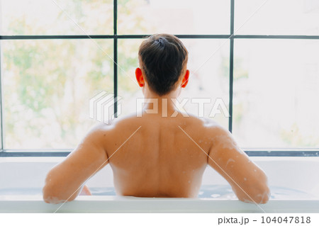 Back of asian man showering in the bathtub. Back of asian man showering in the bathtub. 104047818