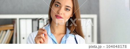 Portrait of beautiful woman doctor holding pen Portrait of beautiful woman doctor holding pen 104048178