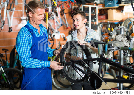 seller in uniform repairing bicycle 104048291