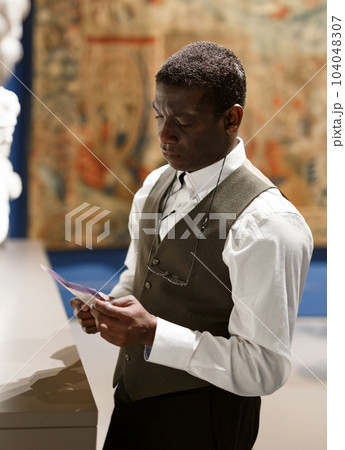 Man reading brochure about exhibits 104048307