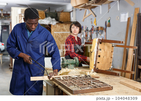 Artisans in process of renewing armchair 104048309