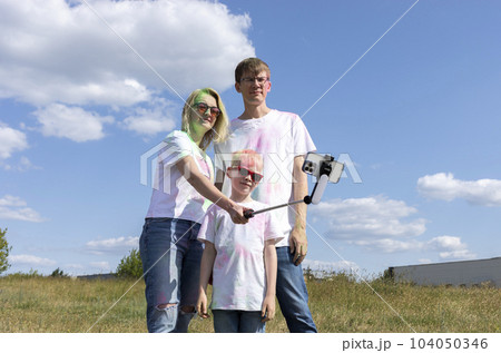 Caucasian Family Takes Photo On Smartphone. Parent, Child With Colorful Dye At Birthday Party Or Celebrating Holi Color Festival. Cheerful Family Spend Time Together. Horizontal Plane 104050346