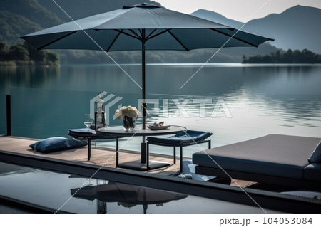 table under a parasol from the sun on the pool terrace on a sunny day 104053084