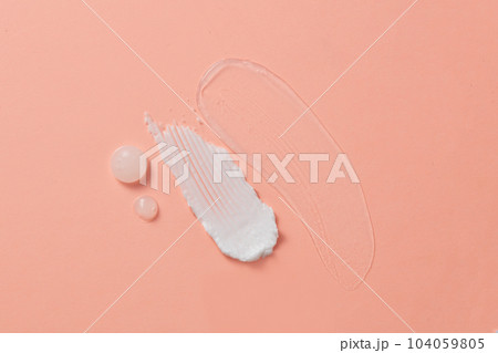 Against the pink background, three textures with the liquid texture of gels, serums and moisturizers decorated. Creative background with blank space for advertising.  104059805