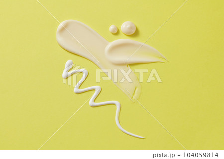 Creamy streaks of moisturizer, lotion, and sunscreen are displayed on a pastel green background. Minimal scene with space for design, advertising and branding cosmetic Creamy streaks of moisturizer, lotion, and sunscreen are displayed on a pastel green background. Minimal scene with space for design, advertising and branding cosmetic 104059814