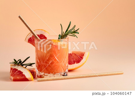 Cocktail with grapefruit, rosemary, and ice in a crystal glass. 104060147