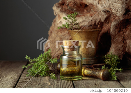 Bottle of thyme essential oil with fresh thyme twigs. Bottle of thyme essential oil with fresh thyme twigs. 104060210