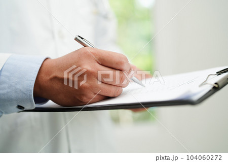 Doctor checking and note diagnosis medicine in clipboard of patients in hospital. 104060272